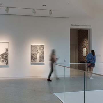 Patrons walk through a gallery at the Nerman featuring artwork by Carlos Rolon