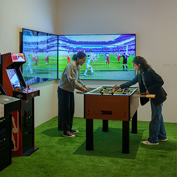 Two patrons playing foosball at the Sport and Spectator exhibition at the Nerman Museum